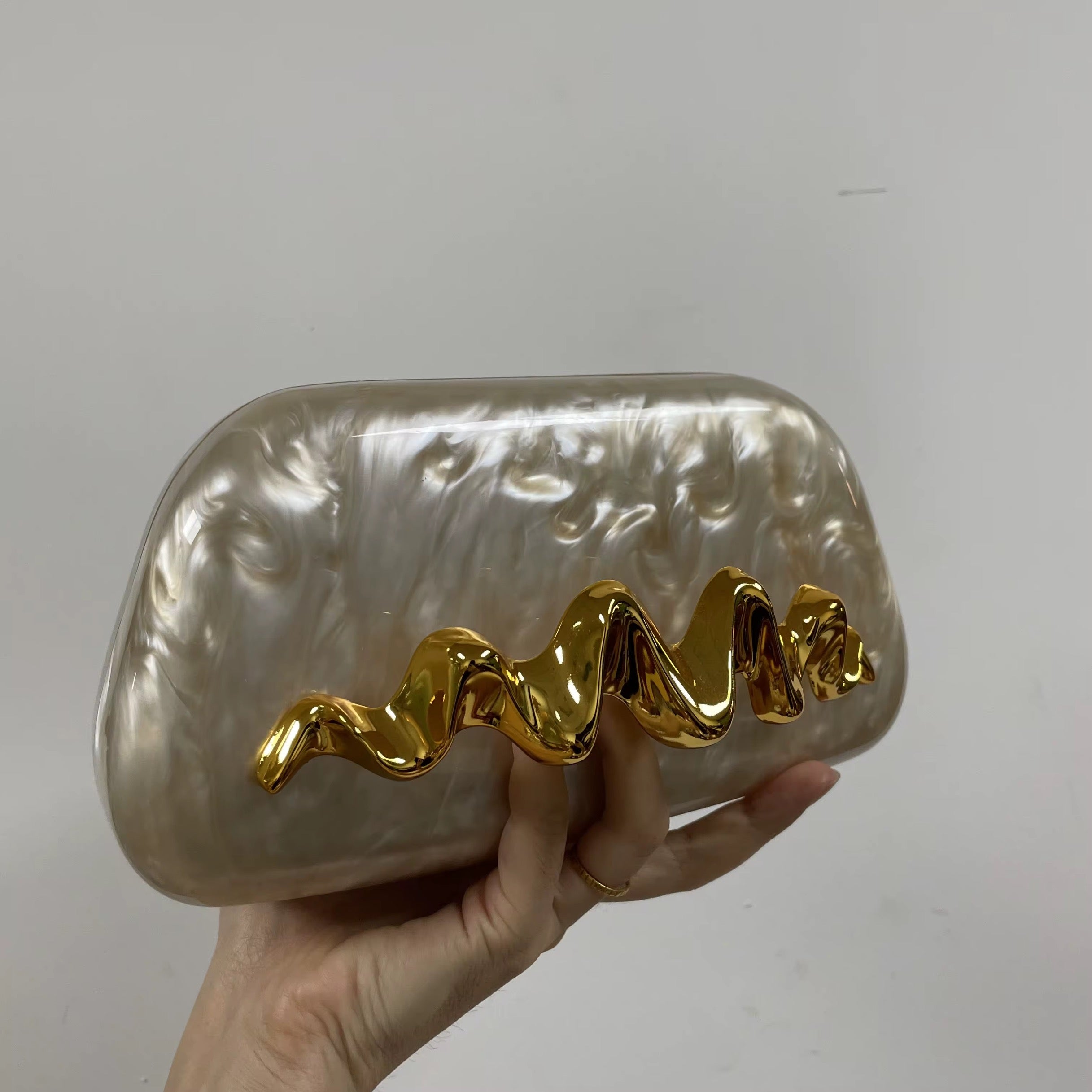 Pearlescent Acrylic Clutch with Sculptural Gold Wave Handle