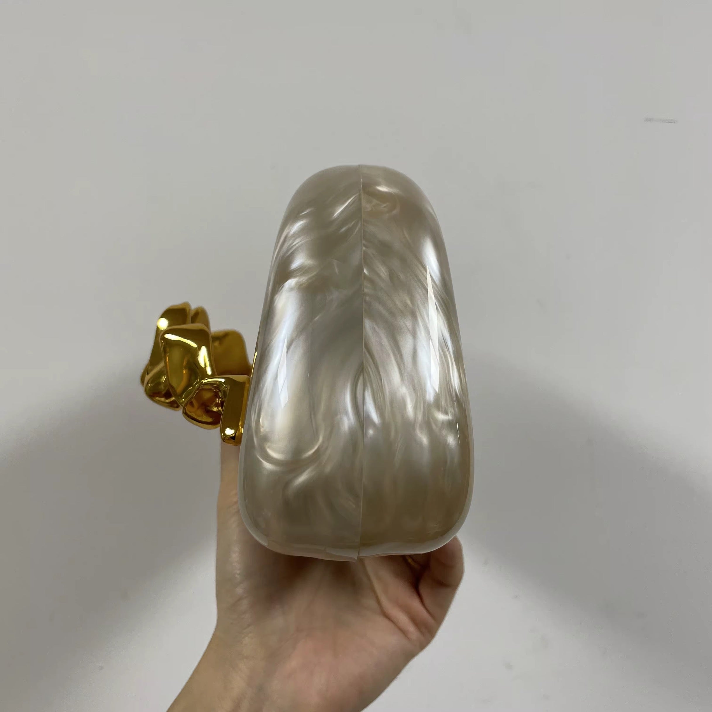 Pearlescent Acrylic Clutch with Sculptural Gold Wave Handle