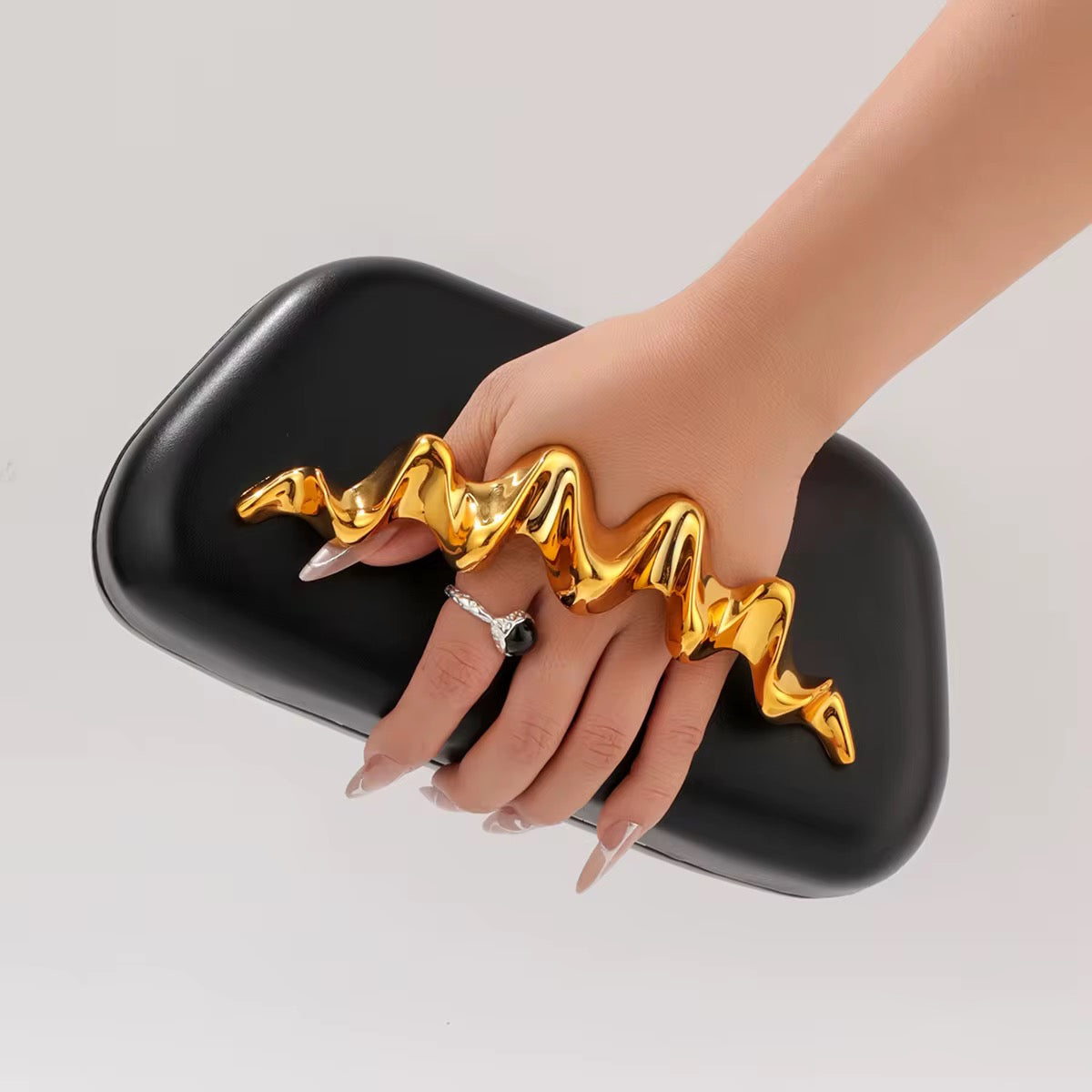 Avant-Garde Black Clutch with Sculptural Gold Hand Grip
