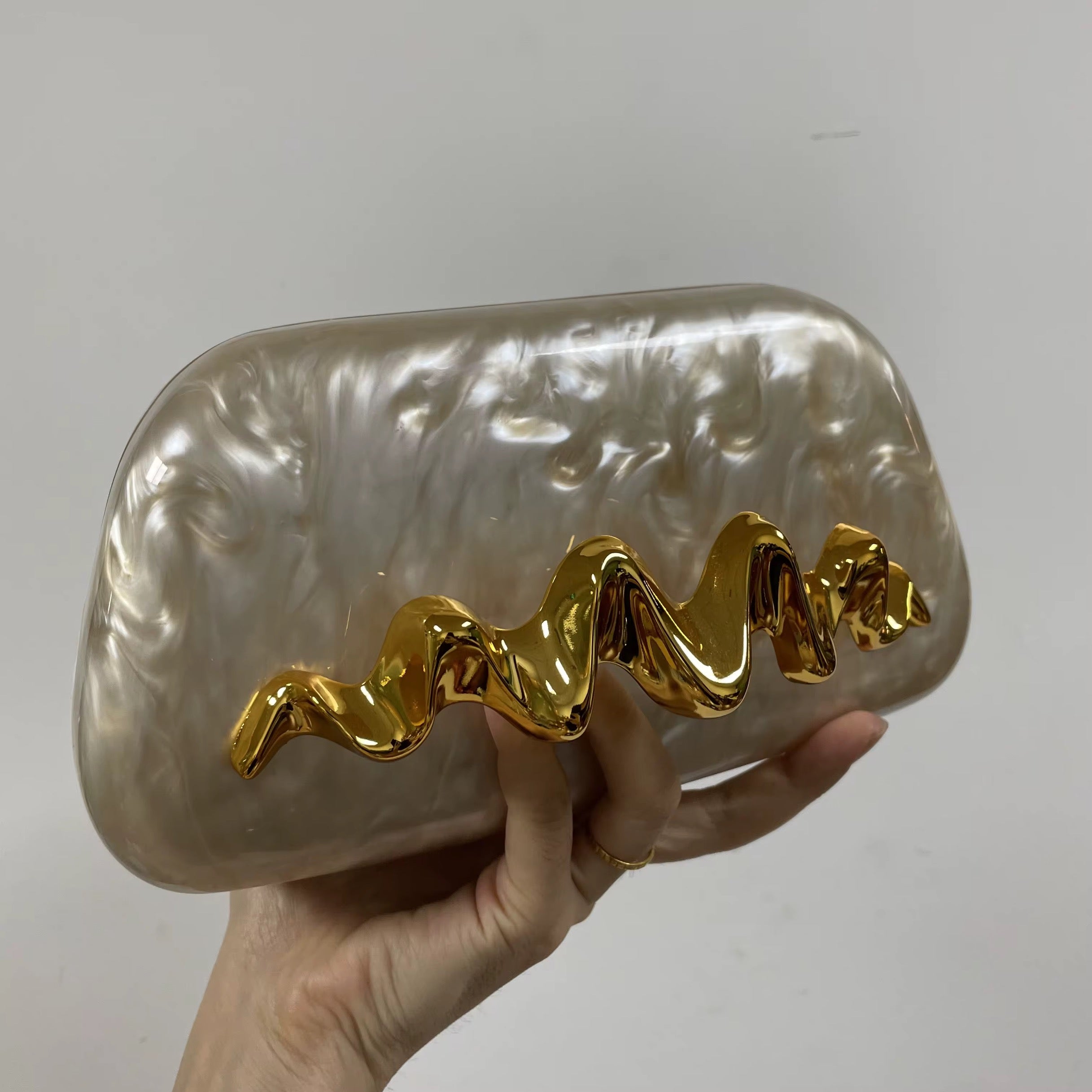 Pearlescent Acrylic Clutch with Sculptural Gold Wave Handle